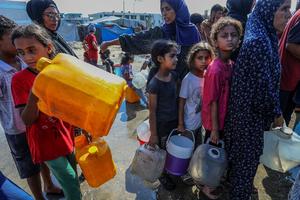 Displaced Palestinians wait for clean drinking water at a shelter inside an UNRWA school in Khan Younis, southern Gaza Strip, on July 22, 2025.