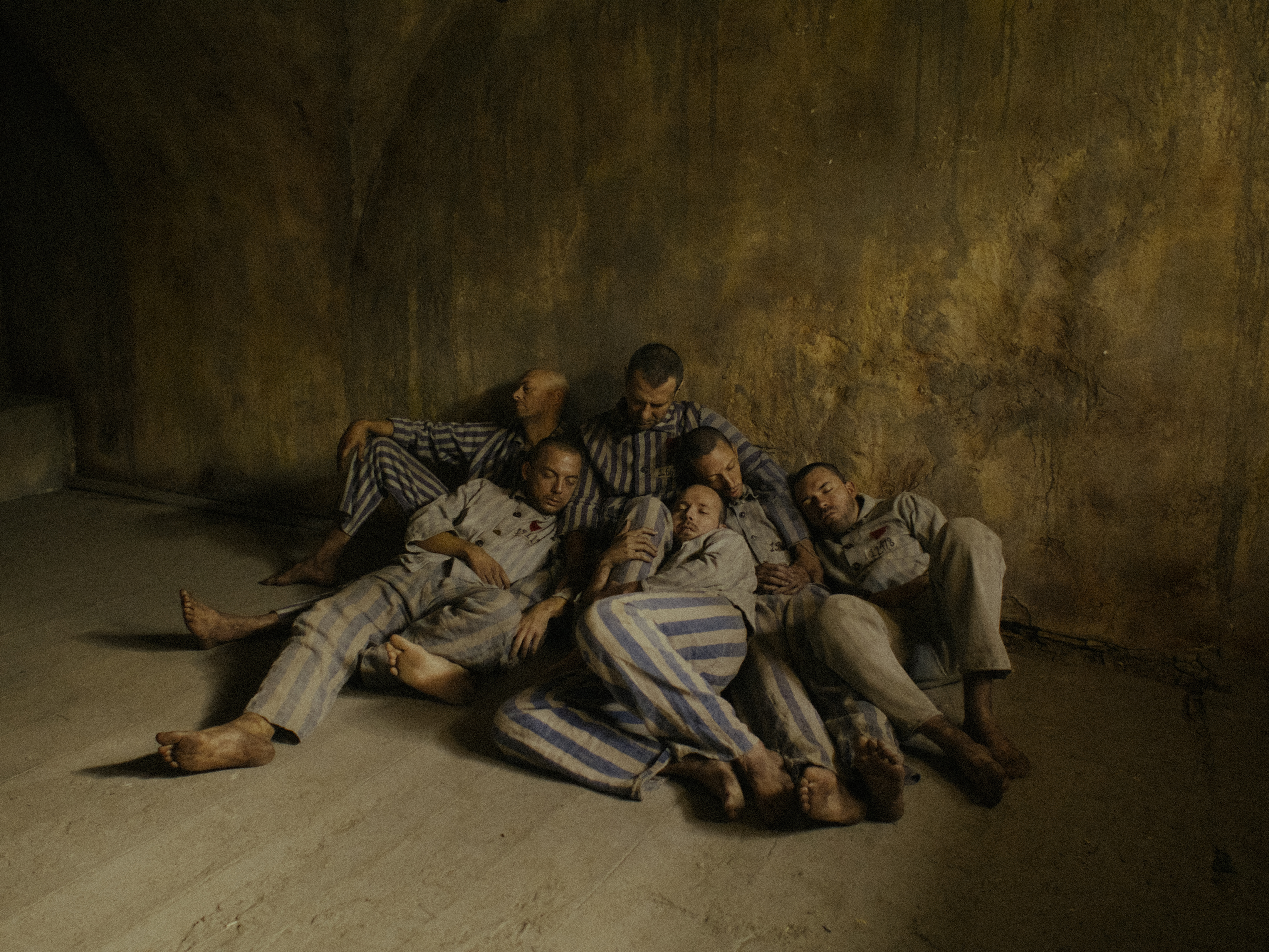 Marcin Kwasny as St. Maximilian Kolbe embraces his fellow prisoners in a moving scene in Triumph of the Heart (2025).