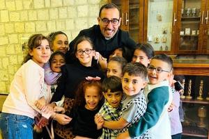 Father Bashar Fawadleh, the Latin pastor of Taybeh, is seen with children from his parish community.