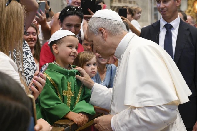 Pope Leo XIV greets a young papal admirer in St. Peter’s Basilica during the general audience on Wednesday, Aug. 20, 2025, at the Vatican. 