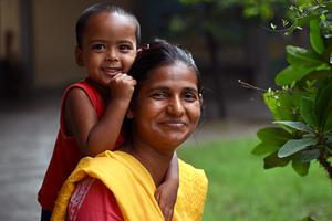 A child at the Catholic-run Mamata Day Care Center in Gazipur, Bangladesh, is carried by one of the center’s “day mothers,” who care for the children of garment workers.