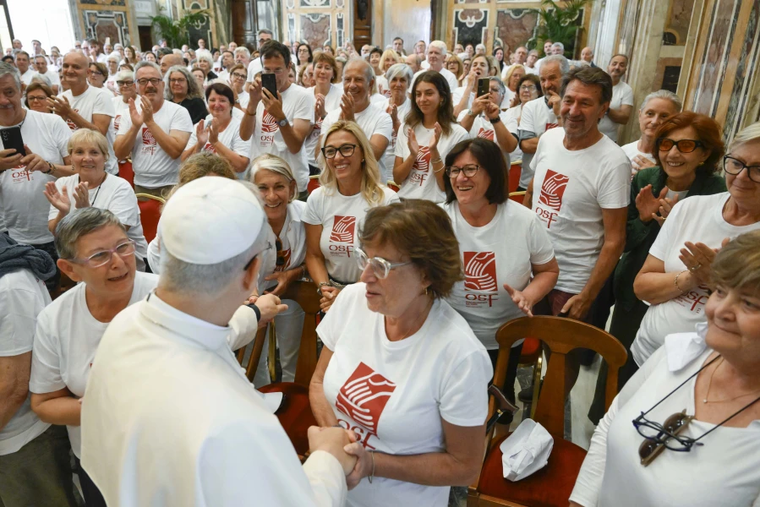 Members of St. Francis' Work for the Poor, wearing t-shirts with the phrase ‘a helping hand to man every day’ with the Holy Father in the Vatican’s Clementine Hall.