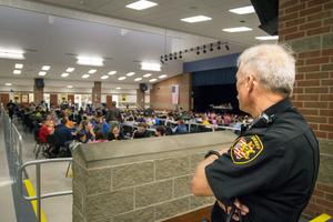 A sheriff’s deputy looks out over students in a Sidney, Ohio, school cafeteria at lunch time.