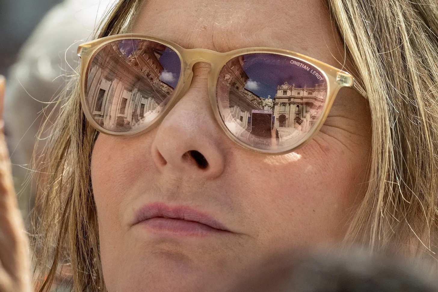 A woman waits in St. Peter's Square.