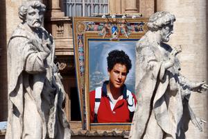 The tapestry of St. Carlo Acutis hangs from a balcony during the canonization Mass Sept. 7 in St. Peter’s Square.