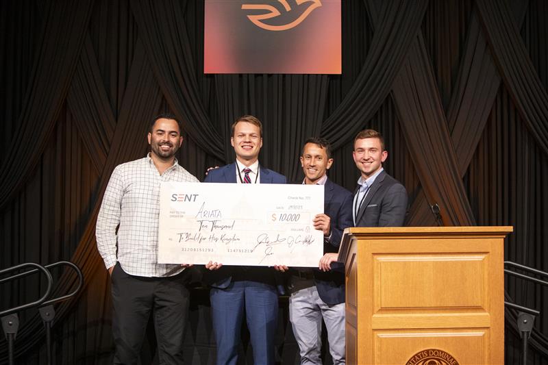 Adam Jace (center left), founder of Ariata, receives the $10,000 top prize from SENT Ventures founder John Cannon (center right) and two others at the SENT Summit's concluding dinner. (Excelsior Road, Inc./SENT Ventures)