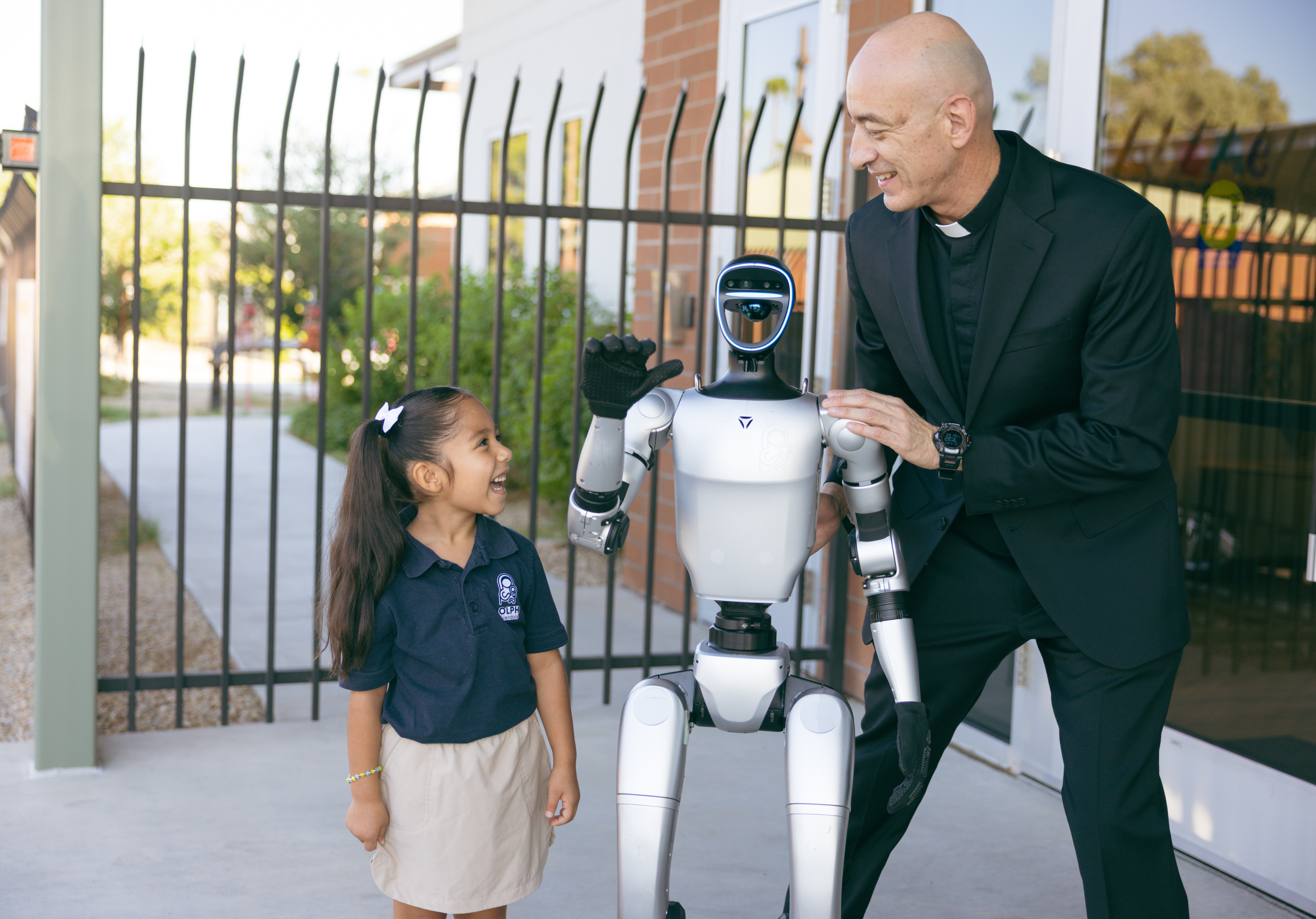 Father Ernesto Reynoso introduces Ben Ben to a student on the campus of Our Lady of Perpetual Help in Glendale, Ariz.