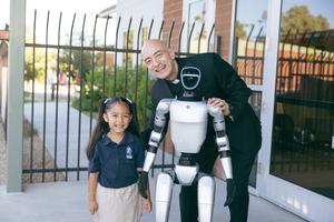 Father Ernesto Reynoso introduces Ben Ben to a student on the campus of Our Lady of Perpetual Help in Glendale, Ariz.