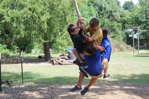 Boys swing on a rope during recess at Western Academy in Houston, where cellphones will be “destroyed” if found.