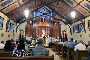 Father Matthew Buettner offers the traditional Latin Mass at St. John the Baptist Catholic Church in Tryon, North Carolina, assisted by several altar servers.
