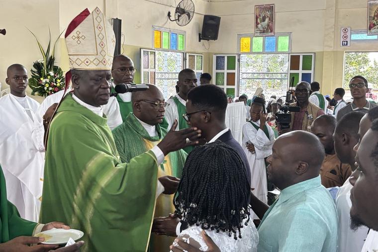 Archbishop Samule Kleda became Douala’s Catholic leader in 2009. Under his leadership, the Catholic population has doubled. Of the 88 parishes under his governance, he built 46. On September 28, he visited the parish of St. Marc de la Cité des Palmiers, where he administered Holy Communion and Confirmation to 90 youth and adults. Here, he gently taps a confirmee on the cheek, as a sign that as a soldier of God, he must now be a willing martyr. Kleda’s predecessor, Cardinal Christian Tumi (1991-2009) was Cameroon’s only cardinal to date. He is buried in Douala’s cathedral.