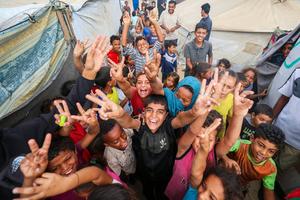 Palestinian children celebrate at a camp for displaced people in Nuseirat in the central Gaza Strip on Oct. 9, following news of a new Gaza ceasefire deal.