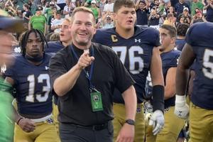 Holy Cross Father Nate Wills cheers from the sidelines.