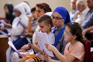 A nun sits with children during Sunday morning Mass at the  Church of the Holy Family in Gaza City on July 20, 2025.  