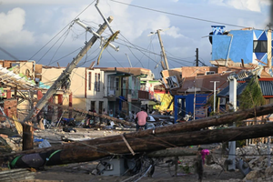 Electrical poles are down as a man bikes through the destroyed neighborhood of North Street following the passage of Hurricane Melissa, in Black River, Jamaica on Oct. 29, 2025. 