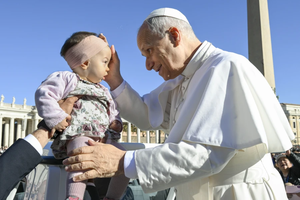 Pope Leo XIV blesses a baby in St. Peter’s Square during his general audience on Wednesday, Nov. 5, 2025, at the Vatican.
