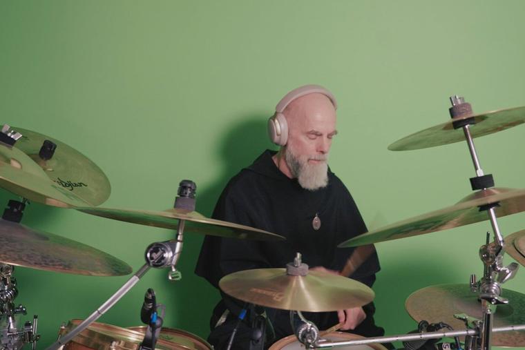 Father Maximilian Mary Dean playing drums in his studio.