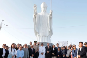 The statue of Pope Leo in Chiclayo, Peru, is surrounded by some of the people who attended its inauguration and blessing.