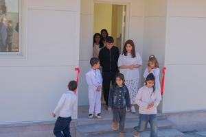 At a ribbon cutting ceremony for the new homes and community, children explore their new environment, which includes a school.