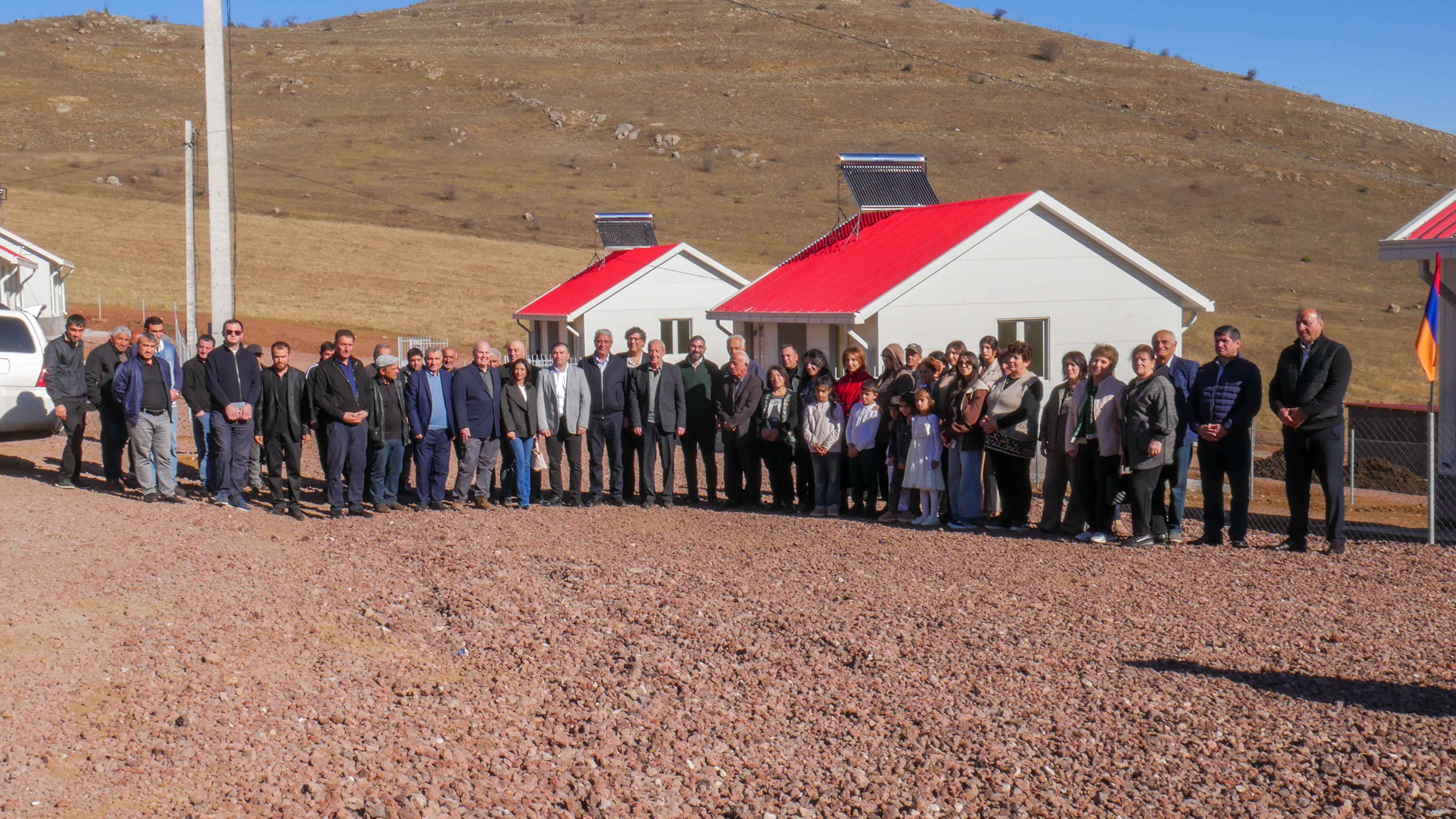 Familias armenias se toman una foto cerca de la nueva comunidad el 18 de noviembre de 2025.