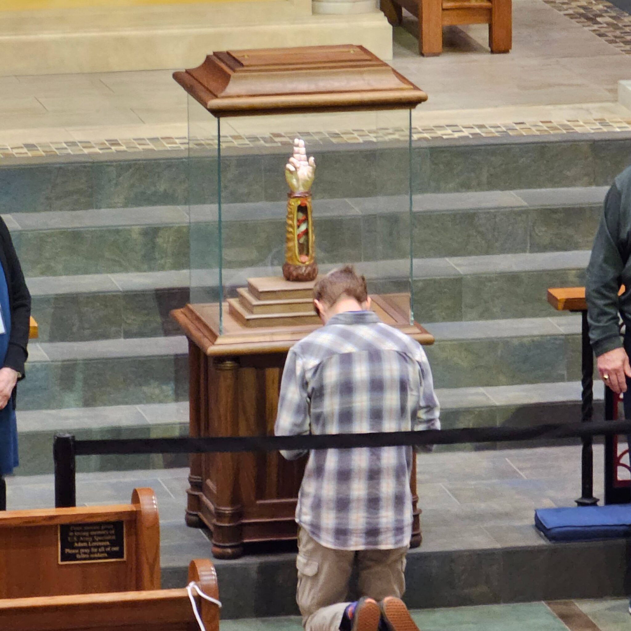 A parishioner prays in front of a relic of St. Jude at Our Lady of the Rosary Catholic Church. 