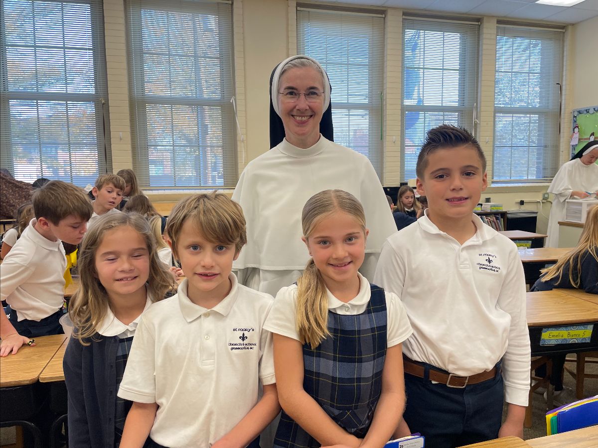 Students smile for the camera with a religious sister on the campus of St. Mary's Catholic School in Greenville, S.C. 