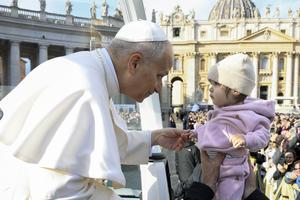 Pope Leo greets a baby during his Nov. 26 general audience.