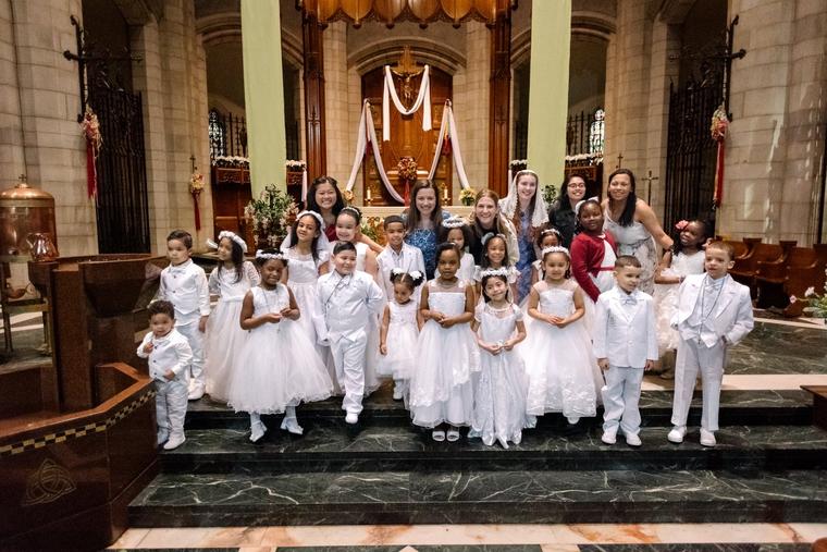 Seton Education Partners pose with children after their baptism. What’s most beautiful is how the children who are taught so often become the ones who lead their families to the Faith.