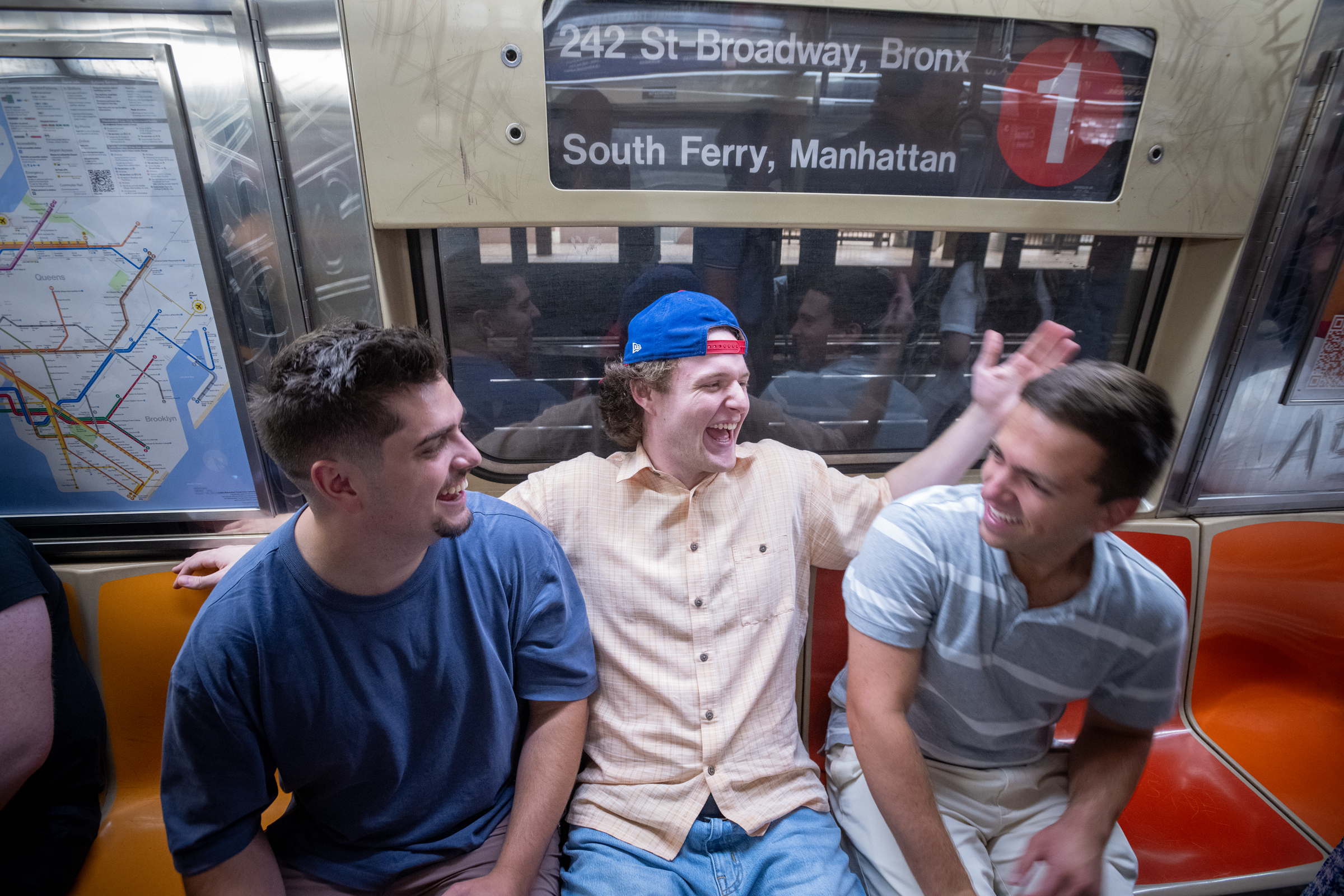 Fellows share time together on the subway ride. 