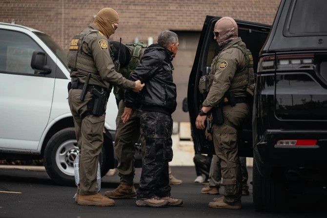 A person detained is taken to a parking lot on the far north side of the city before being transferred to an Immigration and Customs Enforcement facility in Chicago on Oct. 31, 2025.