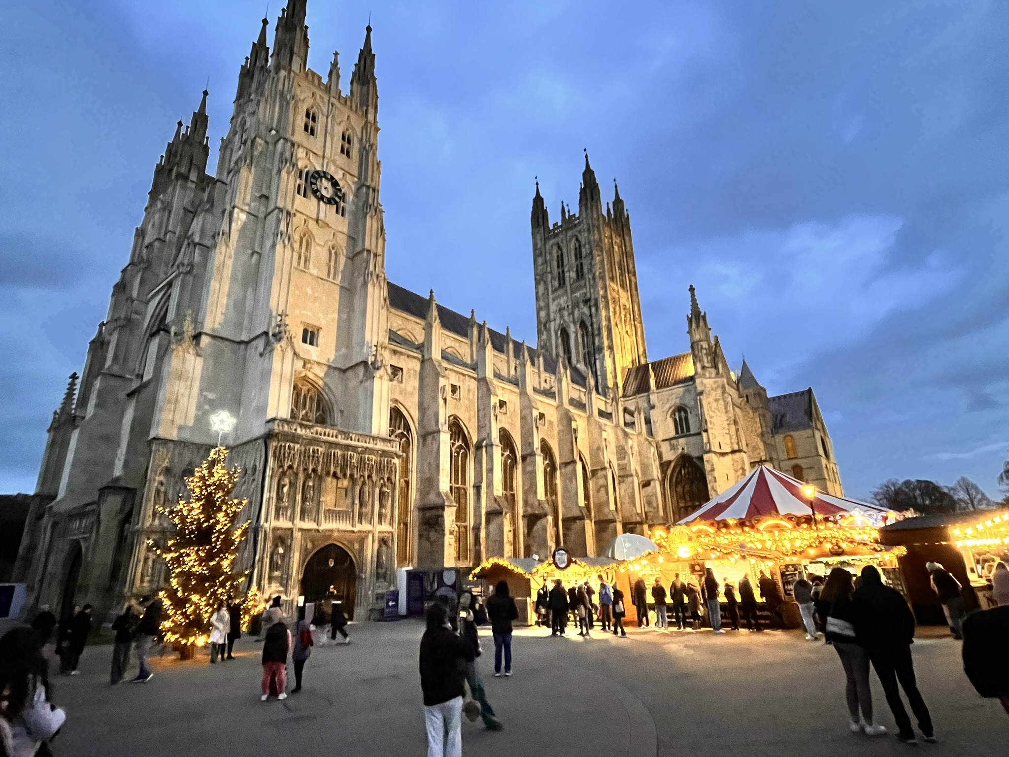 Luzes de Natal brilham em frente à catedral.
