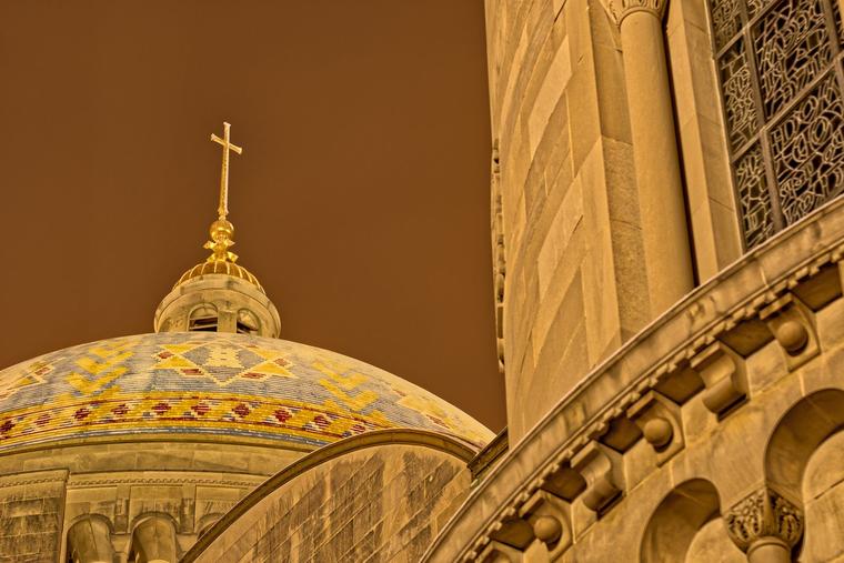 The Basilica of the National Shrine of the Immaculate Conception in Washington, D.C., stands illuminated at midnight on a winter night.