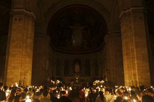 Catholics hold candles during an Easter Vigil Mass in the Basilica of the Sacred Heart of Paris, France in April.