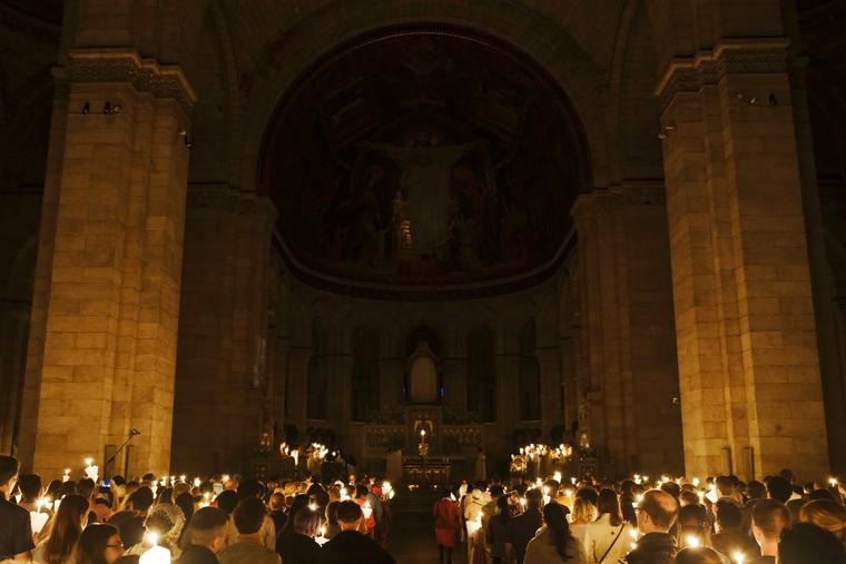 Catholics hold candles during an Easter Vigil Mass in the Basilica of the Sacred Heart of Paris, France in April.