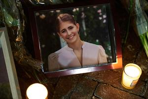 Candles are lit by a framed photo of mass-shooting victim Ella Cook at a makeshift memorial near Brown University in Providence, Rhode Island, on Dec. 15, 2025.
