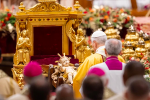 Pope Leo XIV venerates a statue of the Child Jesus during the celebration of Christmas Mass during the night in St. Peter's Basilica on Dec. 24, 2025.