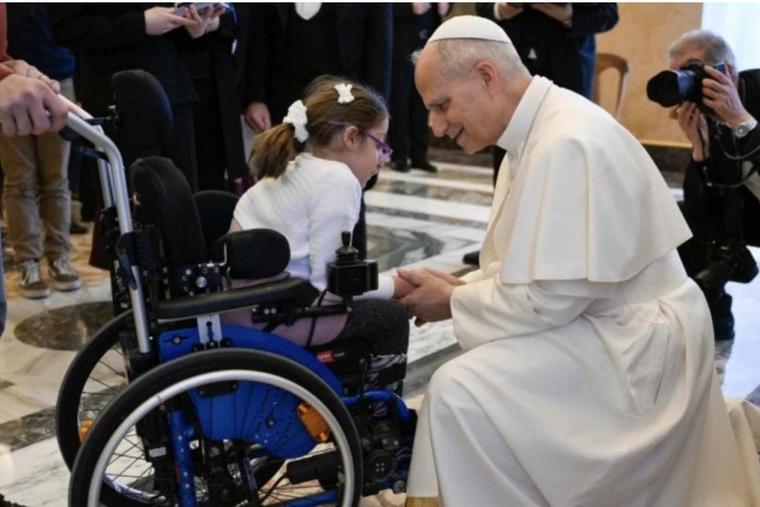 Pope Leo XIV greets a girl in a wheelchair during an audience with members of Italian Catholic Action on Dec. 19, 2025 at the Vatican.