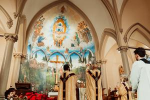 The apse-spanning mural by Joseph Macklin can be seen as Father Chas Canoy celebrates Mass at St. John the Evangelist Church in Jackson, Michigan.