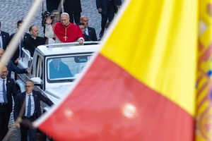 Pope Leo XIV with the Spanish flag in the foreground on Dec. 8, 2025.