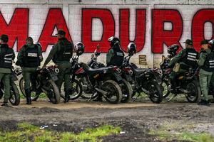 Members of the National Guard stand guard in front of a mural of ousted Venezuela's President Nicolas Maduro in Caracas on January 10, 2026. 