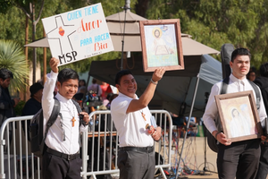 Participants at One Life LA on Jan. 24, 2026, hold signs including, ‘Whoever has love does not hold back when it comes to doing good.’ 