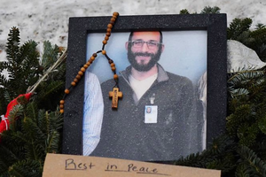 A picture of Alex Pretti is left at a makeshift memorial on Jan. 25 in the area where Pretti was shot dead a day earlier by federal immigration agents in Minneapolis. 
