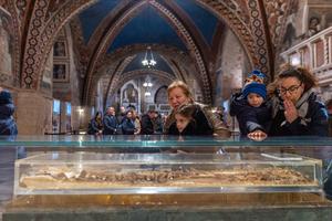 Pilgrims venerate St. Francis of Assisi's relics in the lower church of the Basilica of St. Francis in Assisi, Italy, on Feb. 22, 2026. 