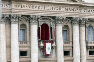 The façade and central balcony of St. Peter’s Basilica stand above St. Peter’s Square at the Vatican.