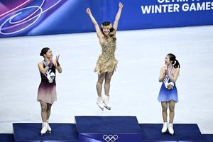 Gold medalist Alysa Liu (center) celebrates on the podium with silver medalist Kaori Sakamoto of Japan (left) and bronze medalist Ami Nakai of Japan after the women’s singles free skate at the 2026 Milano Cortina Winter Olympics at the Milano Ice Skating Arena in Milan Feb. 19, 2026.