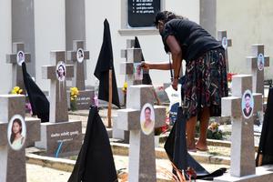 A woman pays tribute to victims of the 2019 Easter Sunday terror attacks at a cemetery in Negombo, Sri Lanka, on April 21, 2022, marking three years since the tragic attacks. -