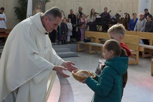 A priest receives the offertory gifts from children during Mass at a parish in the Archdiocese of Olomouc, Czech Republic, in an undated photo.