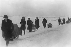 World War II refugees travel through snow-covered terrain in November 1941.