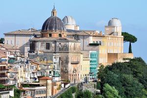 The domes of the Vatican Observatory and Bernini’s Collegiate Church of St. Thomas of Villanova rise above the Apostolic Palace, the traditional papal summer residence, in Castel Gandolfo, Italy.