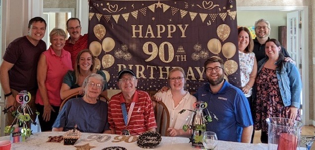 John Angerer celebrates his 9Oth birthday party with his wife on one side and daughter and husband on the other.